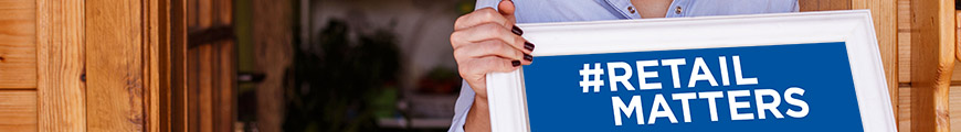 shopkeeper holding retail matters sign