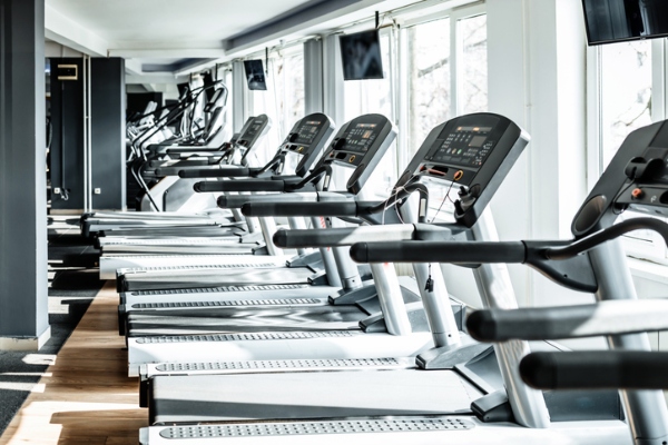 Line of empty treadmills at a gym closed due to COVID-19.